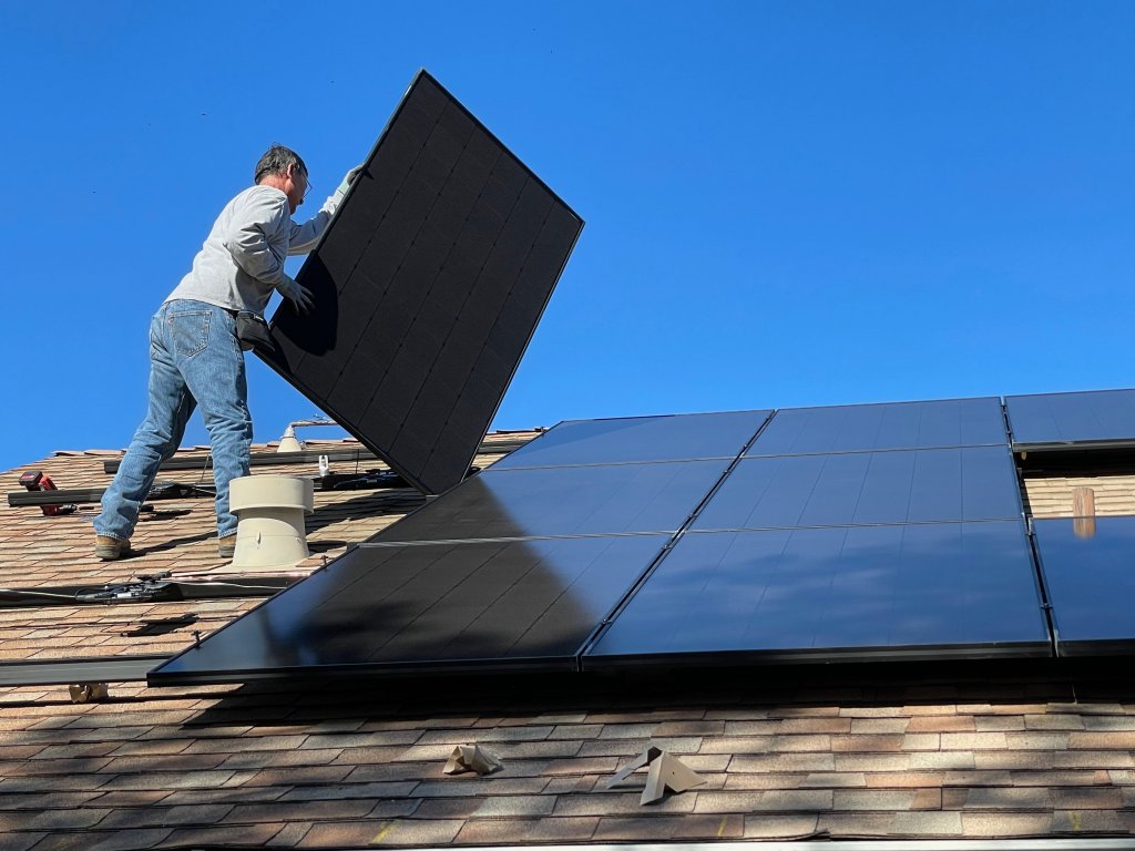 Muškarac postavlja solarne panele na krov