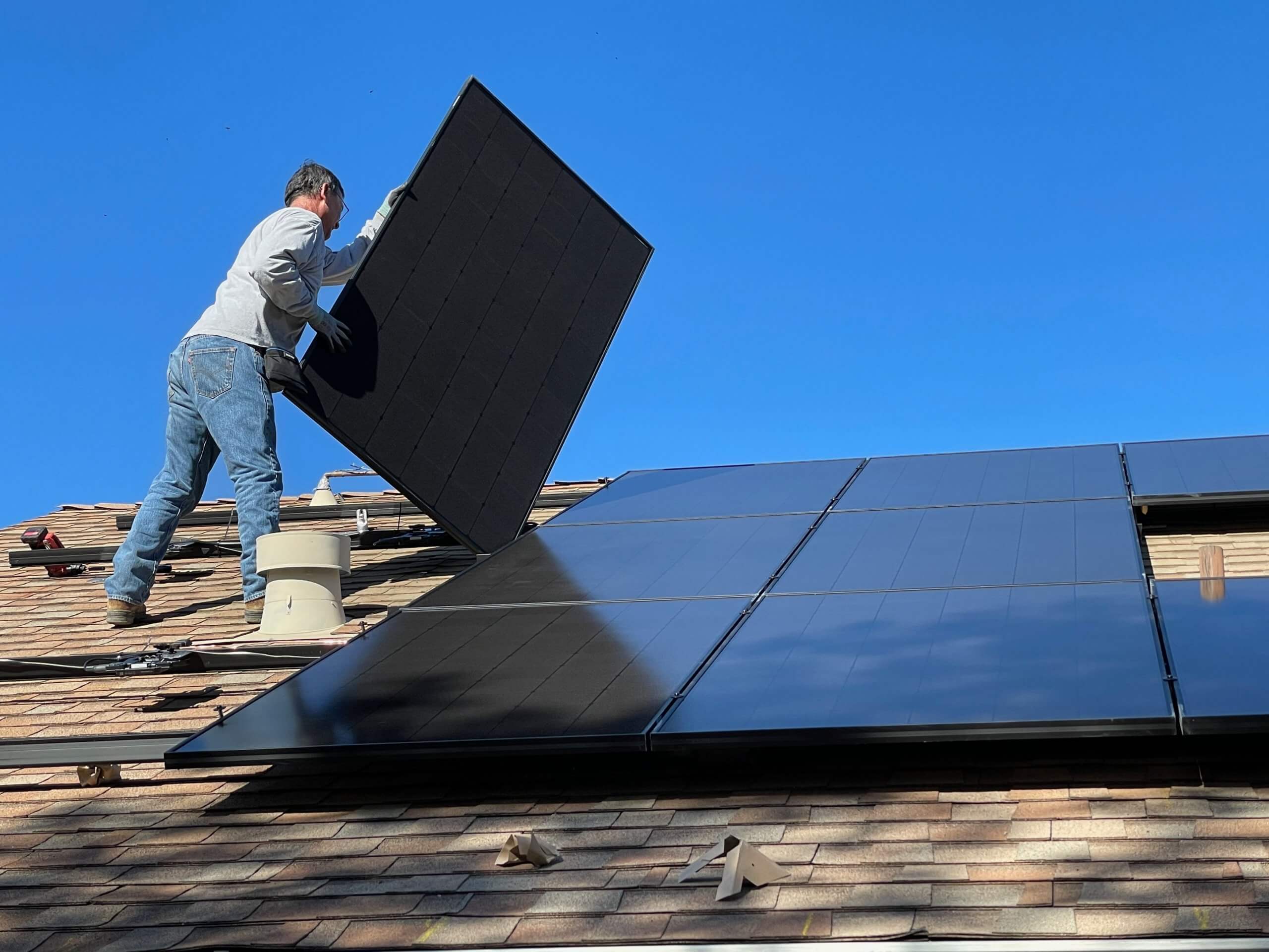 Muškarac postavlja solarne panele na krov